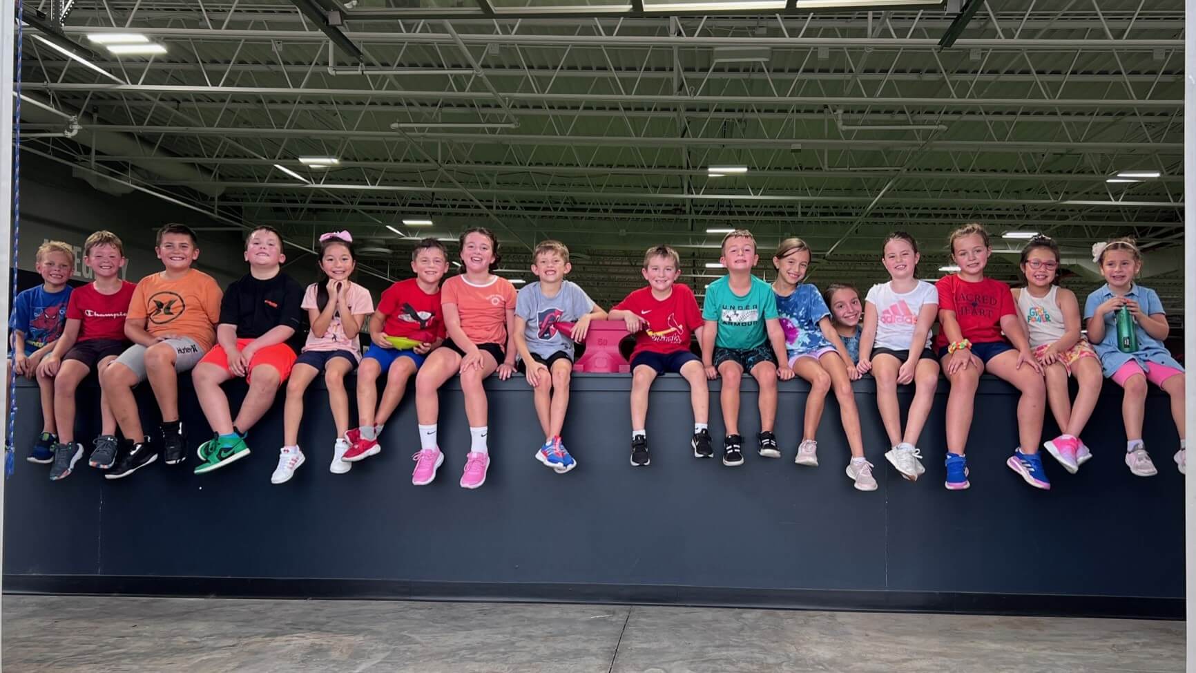 group of kids sitting on a ledge at D1 Training St. Louis West