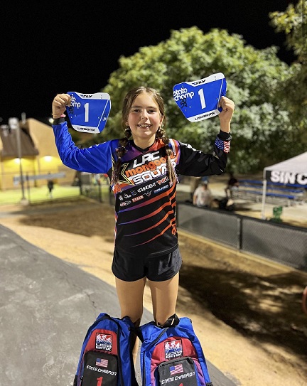 young girl holding awards