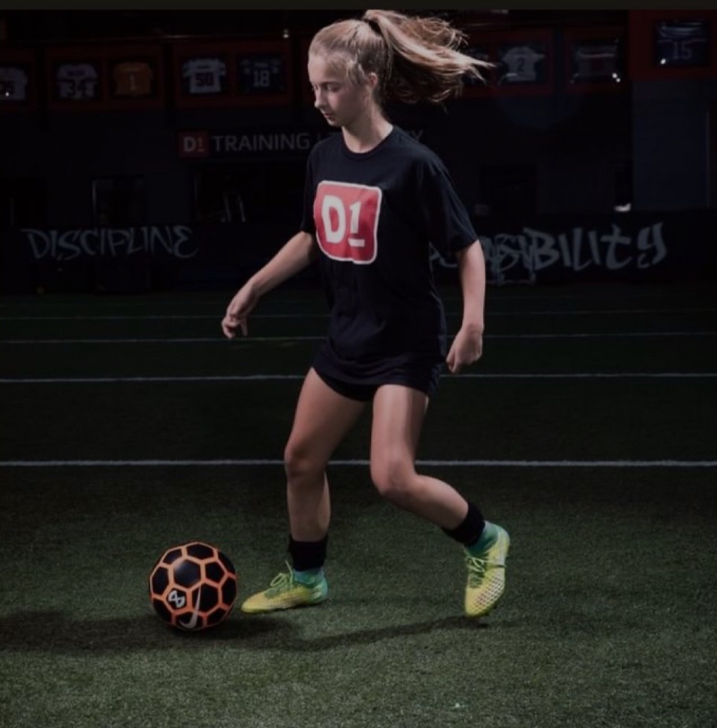 girl kicking around a soccer ball