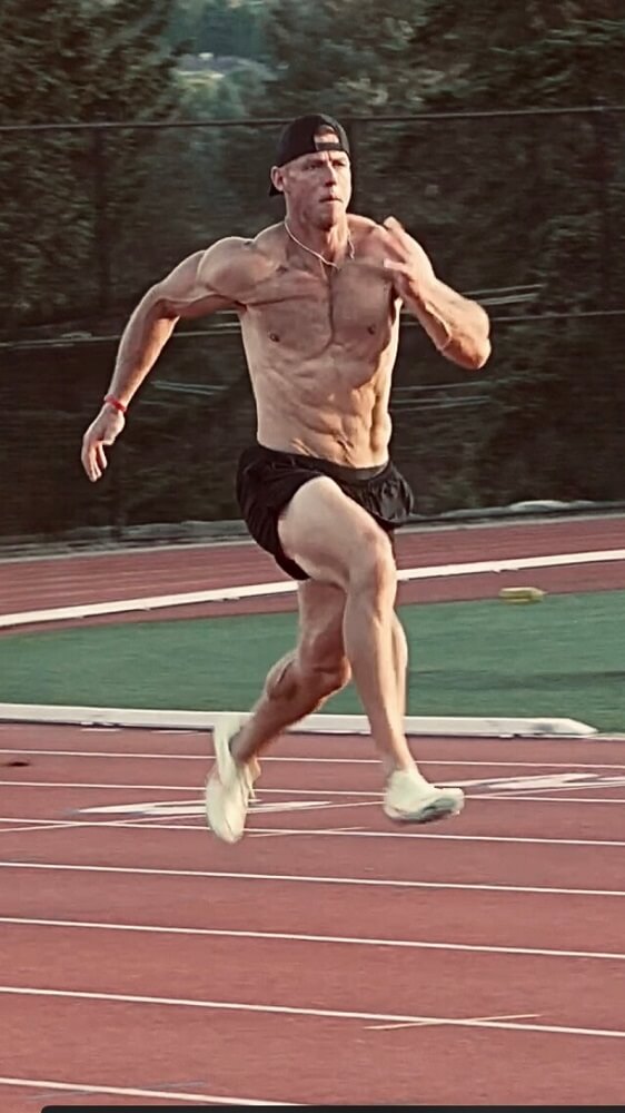 fit shirtless man sprinting on track