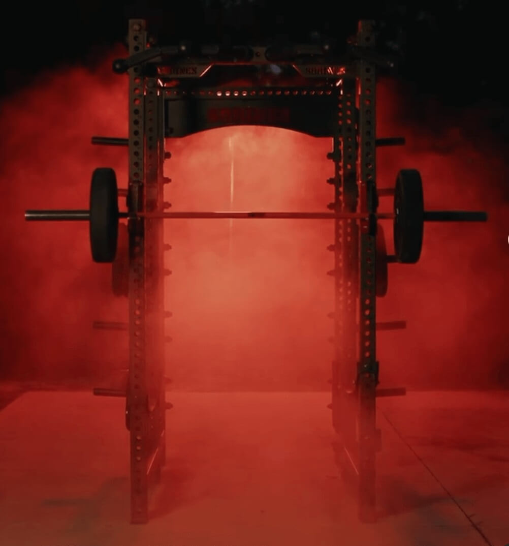 squat rack with red lighting and fog in the background